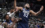 Minnesota Timberwolves' Karl-Anthony Towns (32) and Treveon Graham, left, fight for possession against San Antonio Spurs' LaMarcus Aldridge during the