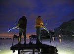 Amid a mayfly hatch, bowfishermen Vaghn Nelson, left, and Scott Stroyny, both of the Twin Cities area, patrol a metro lake Wednesday night, looking fo