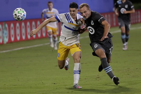 San Jose Earthquakes forward Cristian Espinoza, left, and Minnesota United defender Chase Gasper vie for the ball during the first half of an MLS socc