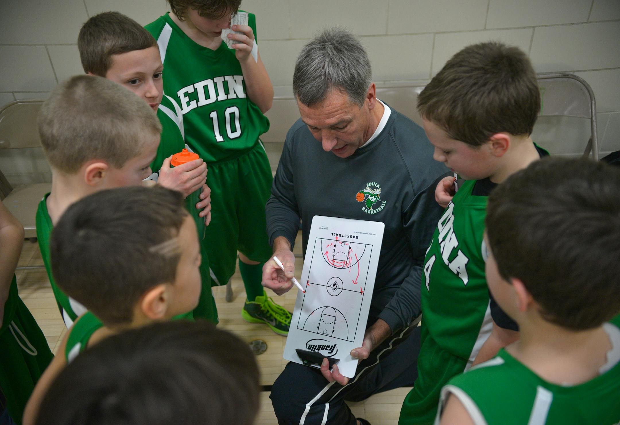 Edina's boys' 4A traveling basketball head coach, Paul Schmidt, outlines an offensive play for his players during a timeout against Chanhassen.