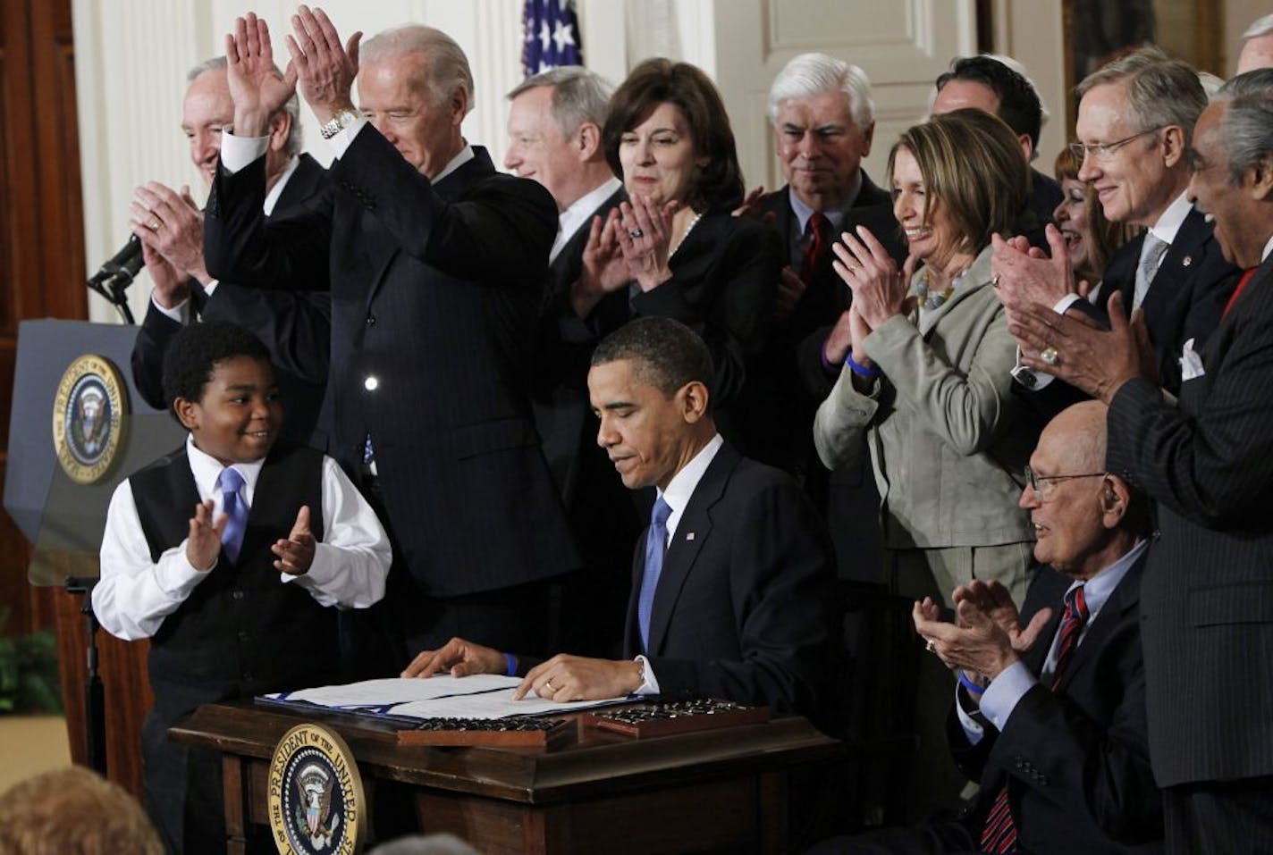 FILE -In this March 23, 2010, file photo President Barack Obama is applauded after signing the Affordable Care Act into law in the East Room of the White House in Washington. If the law survives Supreme Court scrutiny, it will be nearly a decade before all its major pieces are in place, and even if he is re-elected, Obama won't be in office to oversee completion of his biggest domestic policy accomplishment, assuming Republicans don't succeed in repealing it. The law's carefully orchestrated pha