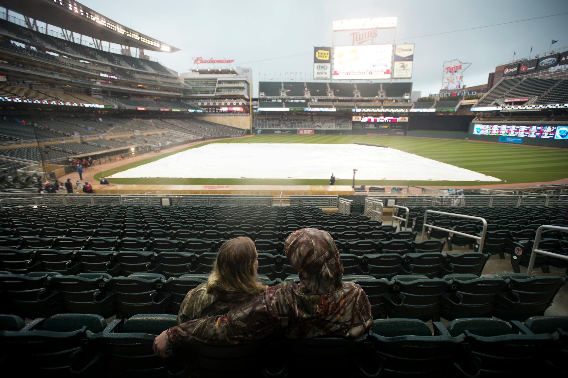 Jake Bieniek, right, put his arm around the shoulder of Ashley Anderson, while waiting in the rain for the start of Friday night's Twins game against the Toronto Blue Jays. ] Aaron Lavinsky � aaron.lavinsky@startribune.com The Minnesota Twins played the Toronto Blue Jays on Friday, May 29, 2015 at Target Field in Minneapolis, Minn.