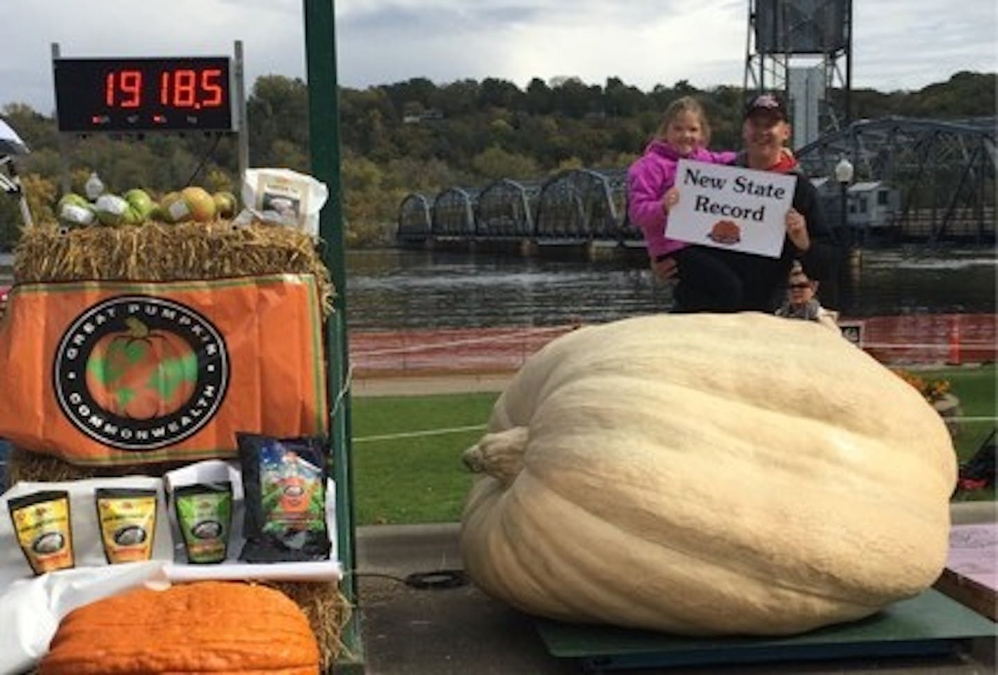 Chris Qualley, with one of his daughters, set a state record with his giant pumpkin.