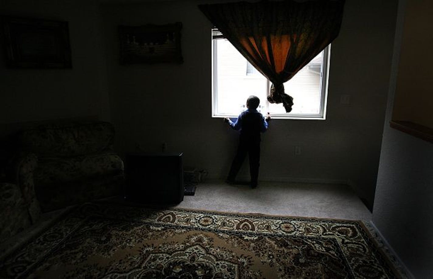 JIM GEHRZ � jgehrz@startribune.com
Burnsville/March 26, 2009/1:30PM
Six-year-old Abdullahi, son of Somali-American mother Idil Abdull, peers from the living room window of the family�s Burnsville home. Abdullahi has autism and Idil has been trying for the past year, to get government authorities to investigate whether there is an unusually high rate of autism among Somali children in Minnesota.