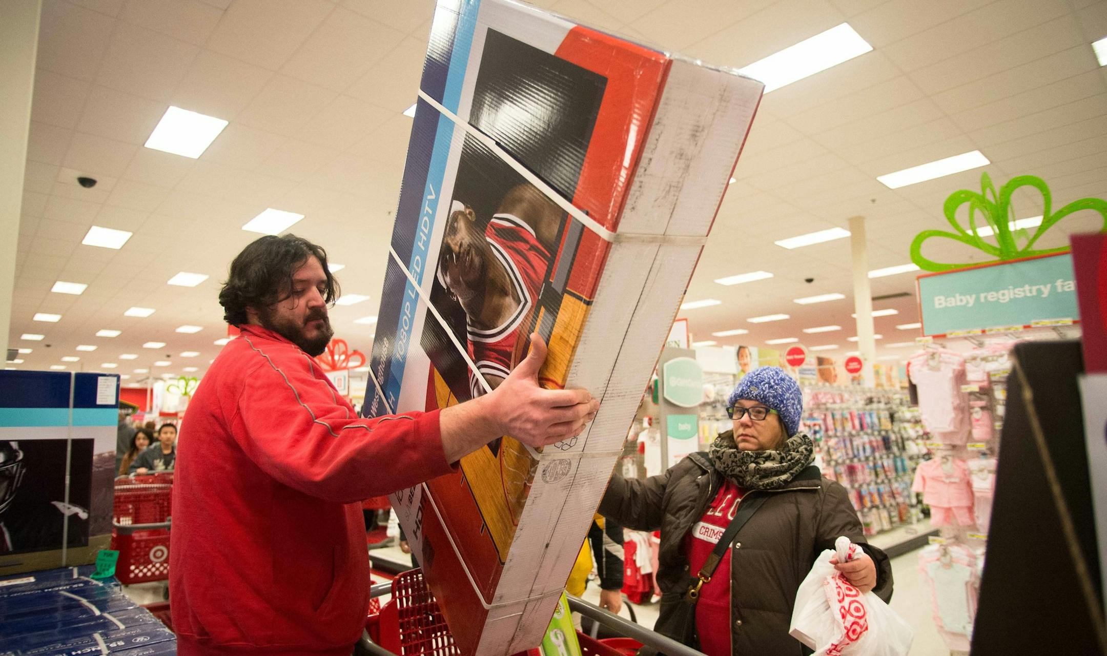 Super Target employee Jeremy Streit helps lift a big screen television into the cart of Tonii Simmons during Thanksgiving night shopping. ] AARON LAVINSKY • aaron.lavinsky@startribune.com Black Friday got an earlier kick off this year on Thanksgiving Day. Shoppers lined up early to be the first to get big deals on their holiday shopping at Target in Roseville Thursday, Nov. 27, 2014. ORG XMIT: MIN1411271928050009