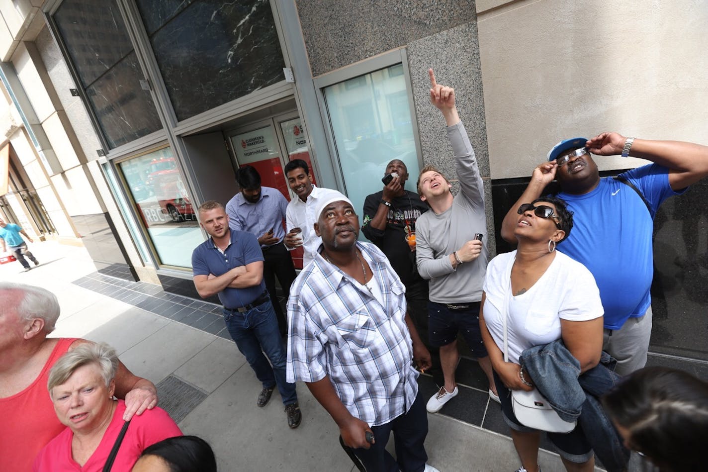 Pedestrians look up near the scene of the rescue at the Wells Fargo tower in downtown Minneapolis on Wednesday, July 8, 2015.