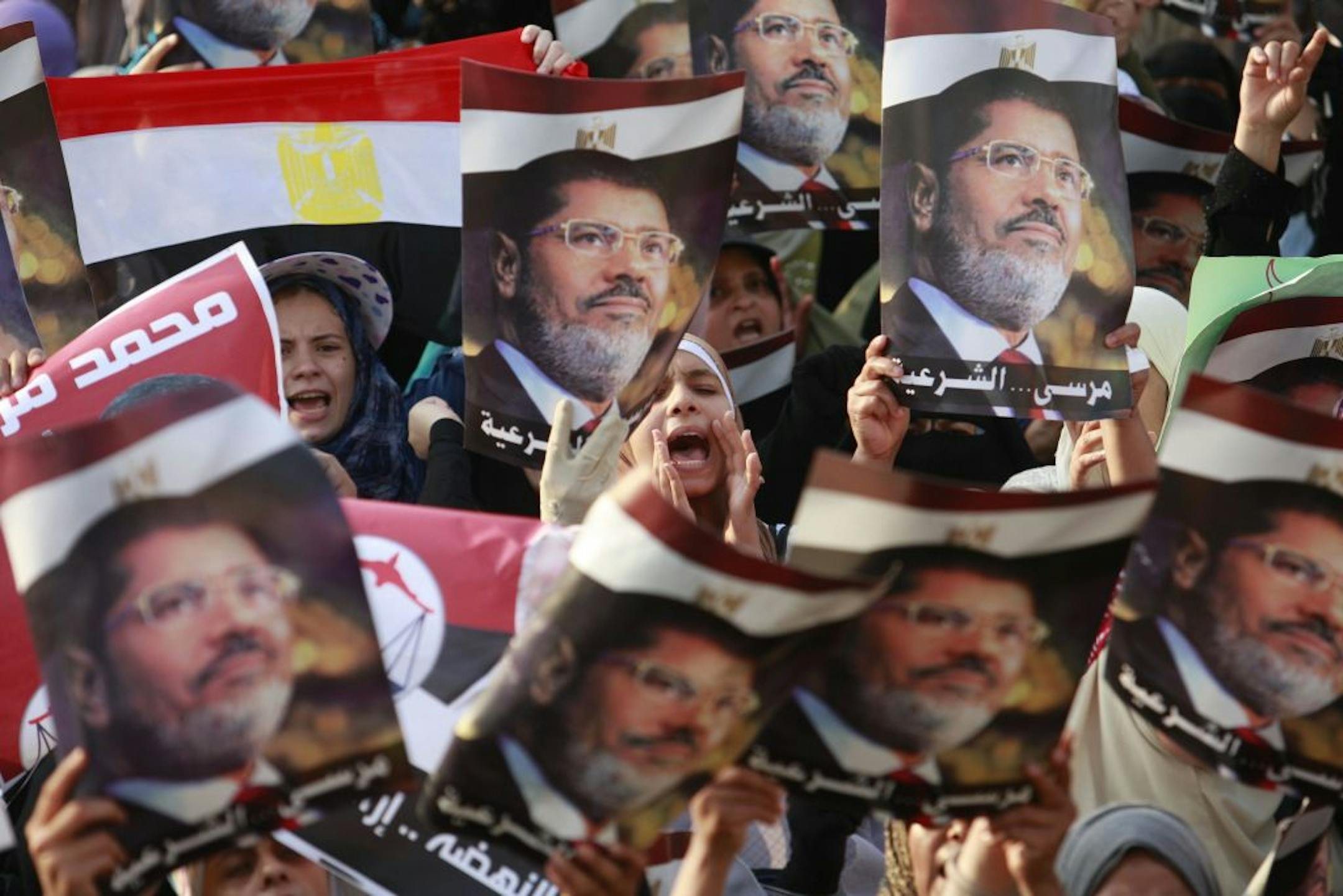 Supporters of the ousted President Mohammed Morsi shout slogans in Nasser City, a suburb of Cairo, Egypt, Monday, July 8, 2013. Egyptian soldiers and police opened fire on supporters of the ousted president early Monday in violence that left dozens of people killed, including one officer, outside a military building in Cairo where demonstrators had been holding a sit-in, government officials and witnesses said.