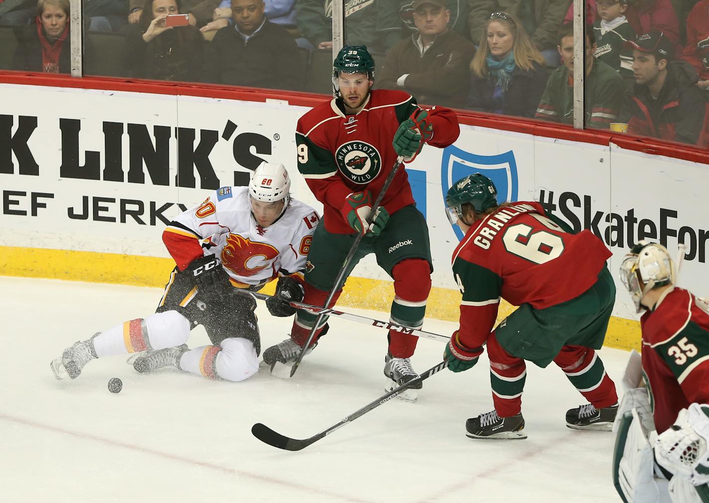 Calgary's Markus Granlund (60) and his brother, the Wild's Mikael Granlund (64) vied for the puck on either side of the Wild's Nate Prosser in the second period of this March 2014 game. Markus is now with Vancouver, the Wild's opponent Tuesday.