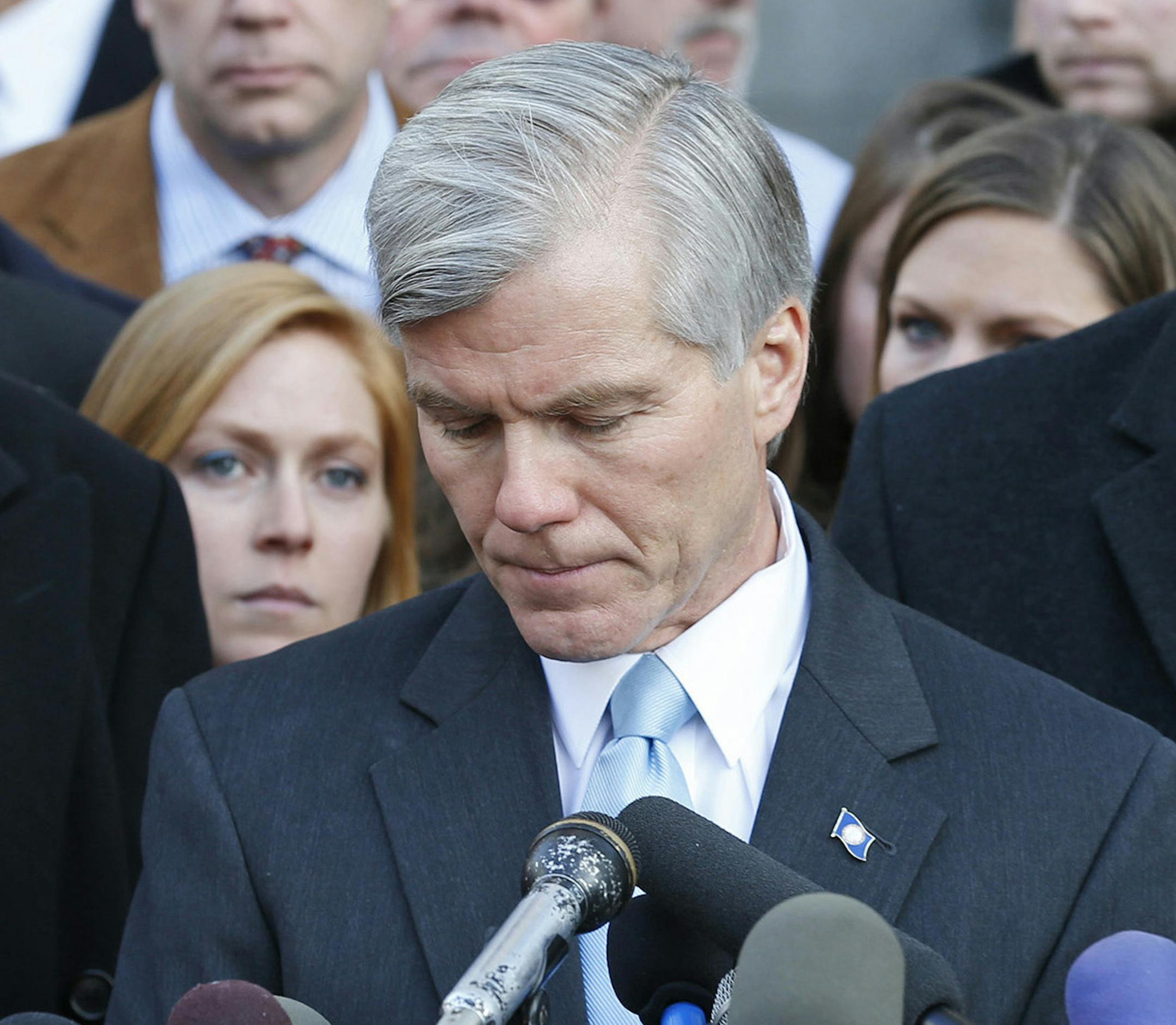 Former Virginia Gov. Bob McDonnell, center, composes himself as he addresses the media outside federal court in Richmond, Va., Tuesday, Jan. 6, 2015. McDonnell was sentenced to two years prison and two years probation in his corruption case. His attorney's Henry Asbill, left and John Brownlee, right, look on. McDonnell is to report to prison by Feb. 9. His wife, who was convicted on eight counts of corruption, will be sentenced Feb. 20. (AP Photo/Steve Helber) ORG XMIT: RIC110