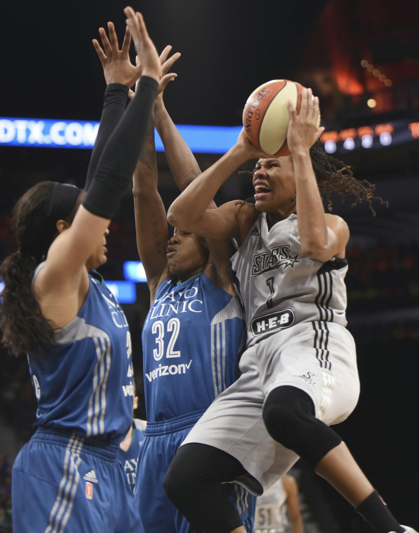 San Antonio Stars Monique Currie (1) drives to shoot as Minnesota's Maya Moore, left, and Rebekkah Brunson defend during a WNBA basketball game in the AT&T Center, Tuesday, July 12, 2016, in San Antonio. The Lynx won 81-57. (Billy Calzada/The San Antonio Express-News via AP)