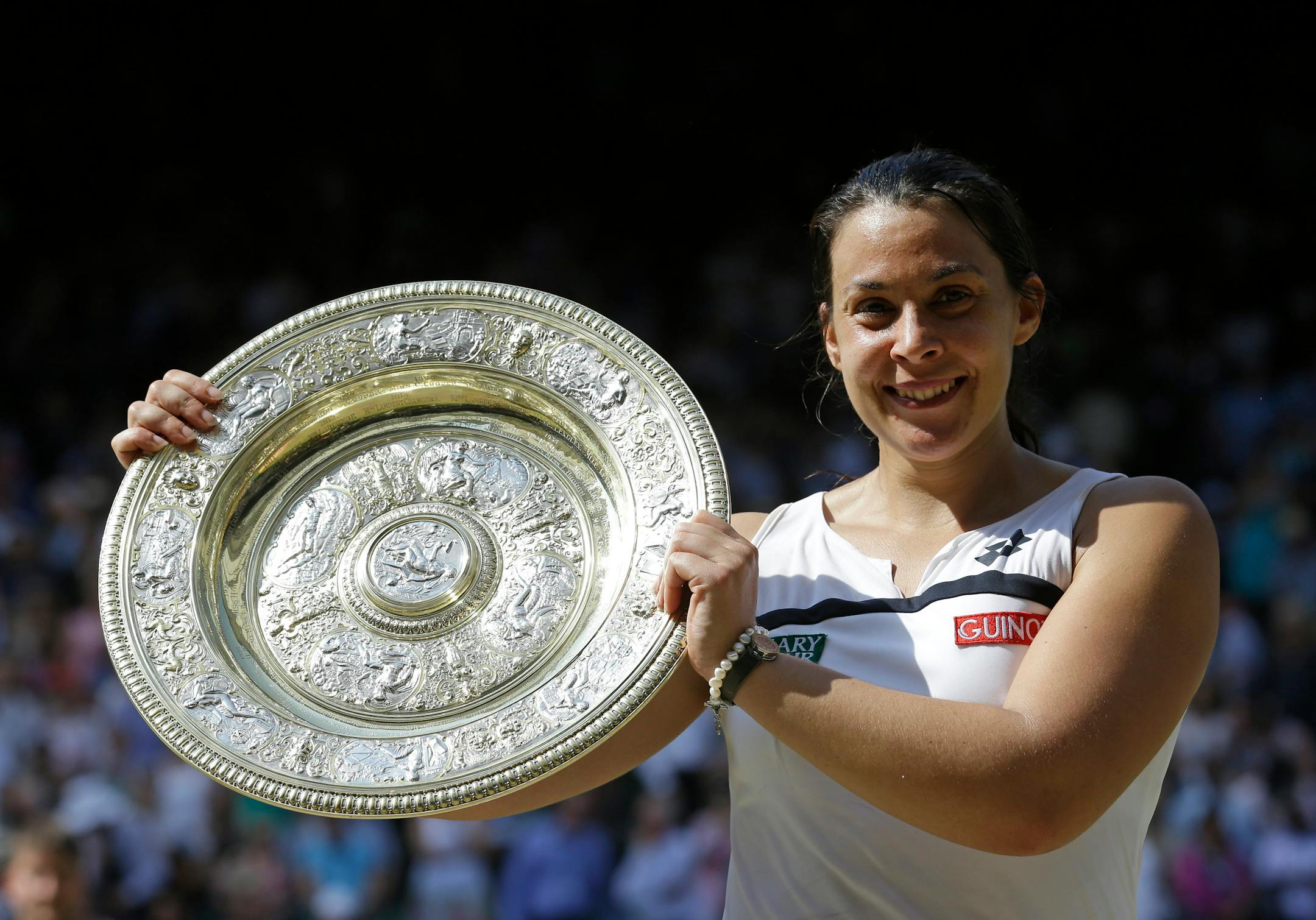 Marion Bartoli of France smiles as she holds the trophy after winning the Women's singles final match against Sabine Lisicki of Germany at the All England Lawn Tennis Championships in Wimbledon, London, Saturday, July 6, 2013. (AP Photo/Anja Niedringhaus)