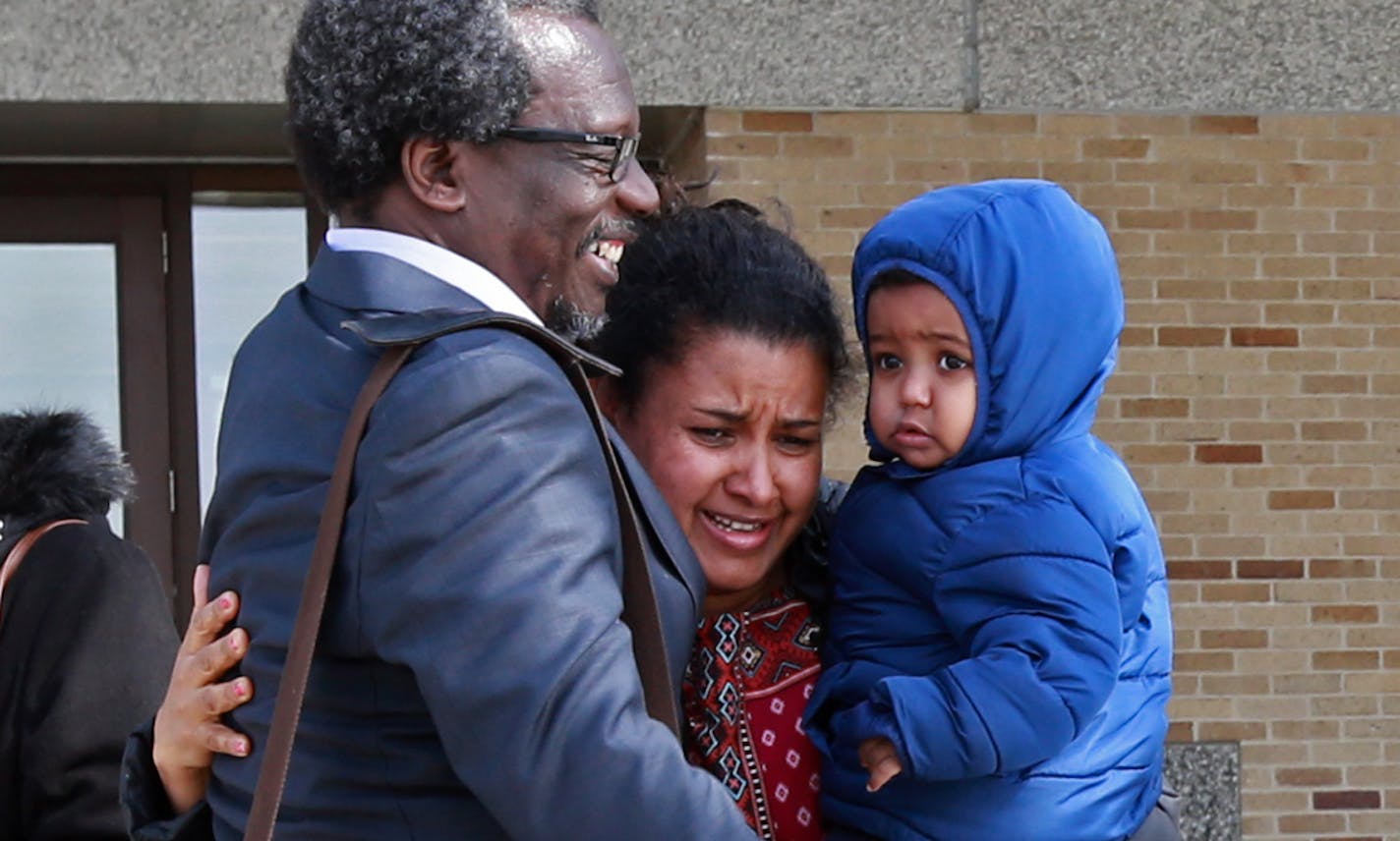 Augsburg Professor Mzenga Aggrey Wanyama embraces his family outside the Immigration and Customs Enforcement's headquarters in Saint Paul after attending a meeting with immigration officials on Friday, March 9, 2018 outside. The professor was greeted by protestors who denounce his deportation to Kenya after living in the United States for 16 years. [Ellen Schmidt &#xef; ellen.schmidt@startribune.com {building is technically Henry Whipple Federal Building