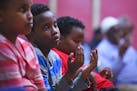 Yahya Eyow, 10, takes part in a prayer at the end of the service for his father. Friends and acquaintances from Ahmed Eyow's professional, religious a
