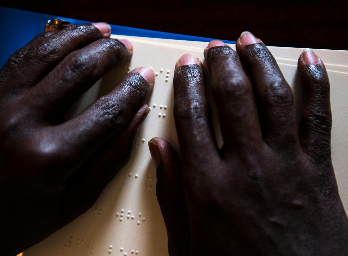 Abdikadir practices reading braille Thursday at the Capitol Cafe in Minneapolis. ] (AARON LAVINSKY/STAR TRIBUNE) aaron.lavinsky@startribune.com Longtime Somali mentor and mathematician, Abdikadir Adan Mohamed "Xiito" is working to push through the challenges of blindness while continuing to help and tutor children in the community with mathematics.