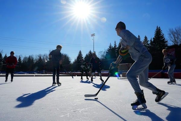 Seth Stoutenburg, 20, of Roseville moves the puck down the ice while playing a game of pick up hockey as temperatures soared into the 50's Thursday, D