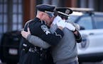 Taylor Jacobs, center, who was with Burnsville police for 10 years, embraced honor guard members Tuesday outside the Ballad-Sunder Funeral and Cremati