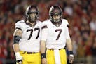 Gophers starting center Tyler Moore (77, with quarterback Mitch Leidner) announced his intention to transfer Monday.
