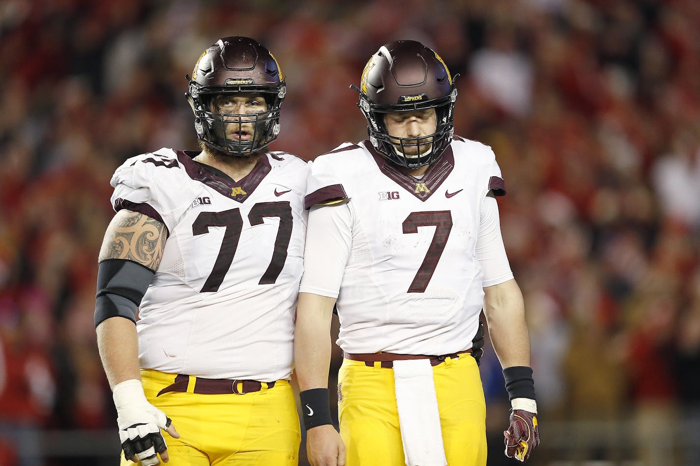 Gophers starting center Tyler Moore (77, with quarterback Mitch Leidner) announced his intention to transfer Monday.