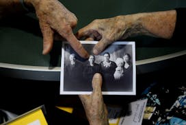 Lil Leuthard Ritter and Sister Agatha Grossman look at an old photo of Joseph Schmid and his immediate family.