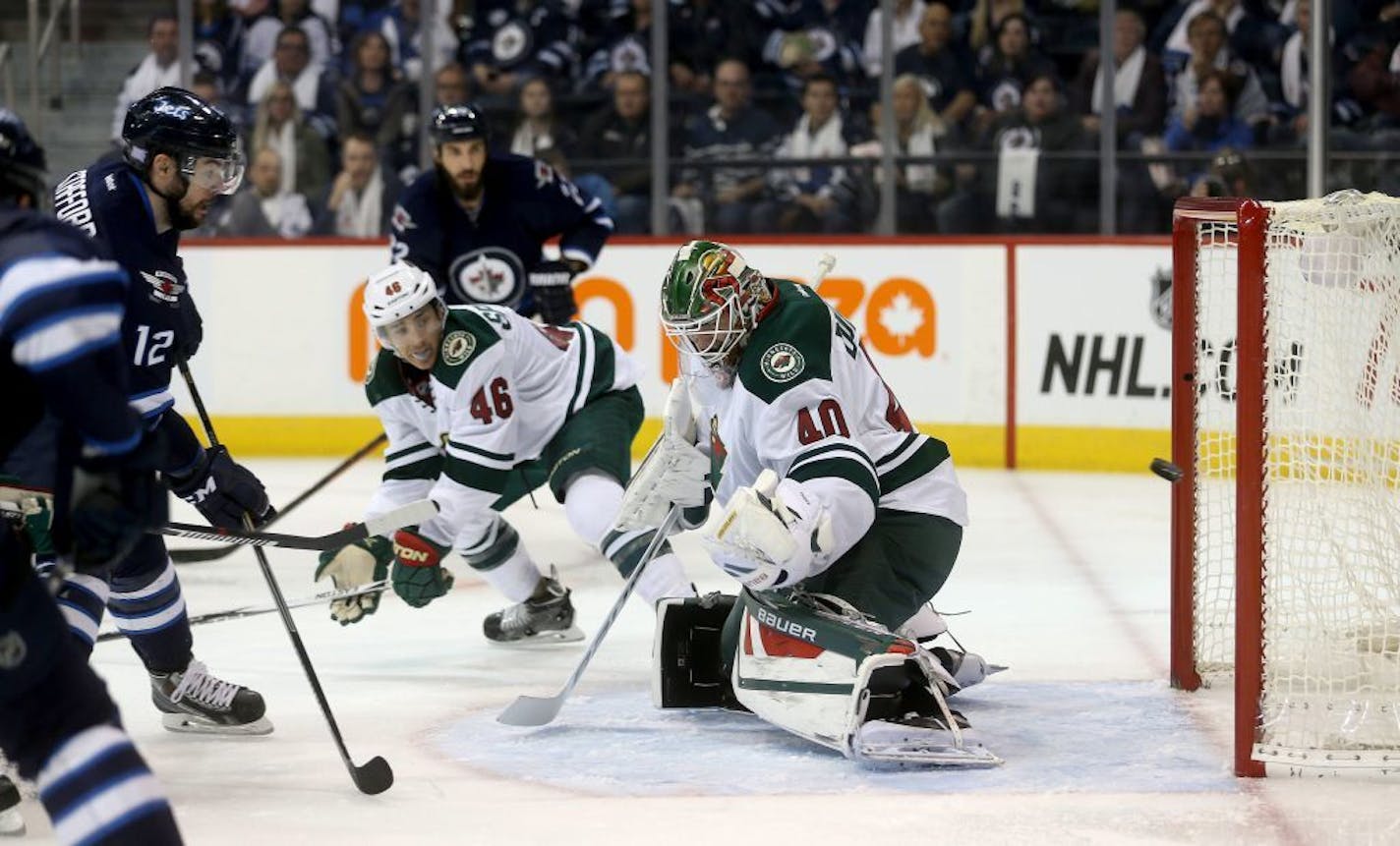 Winnipeg Jets' Drew Stafford (12) scores on Minnesota Wild goaltender Devan Dubnyk (40) during second period NHL hockey action in Winnipeg, Sunday, Oct. 25, 2015.