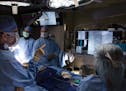 Dr. Gustavo Oderich, left, Dr. Animesh Rathore, Dr. Peter Gloviczki, and surgical technologist Brenda Mathews prepare to put an experimental stent int