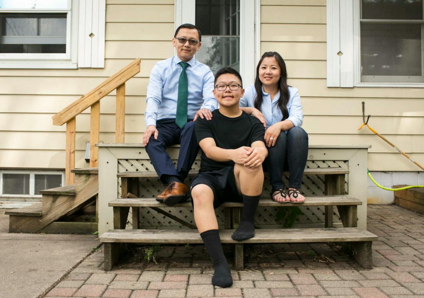 Dmitri Moua, center, and his parents at their home in Minnesota. Dmitri loves to dance but can't dance competitvely with his team and has to sit on the sidelines because of a Minnesota rule.