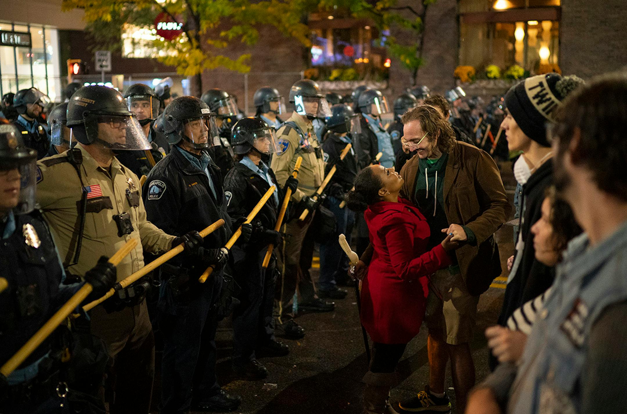 A couple danced between the lines of police and protesters as President Donald Trump held a campaign rally in Target Center on Thursday, Oct. 10, 2019.