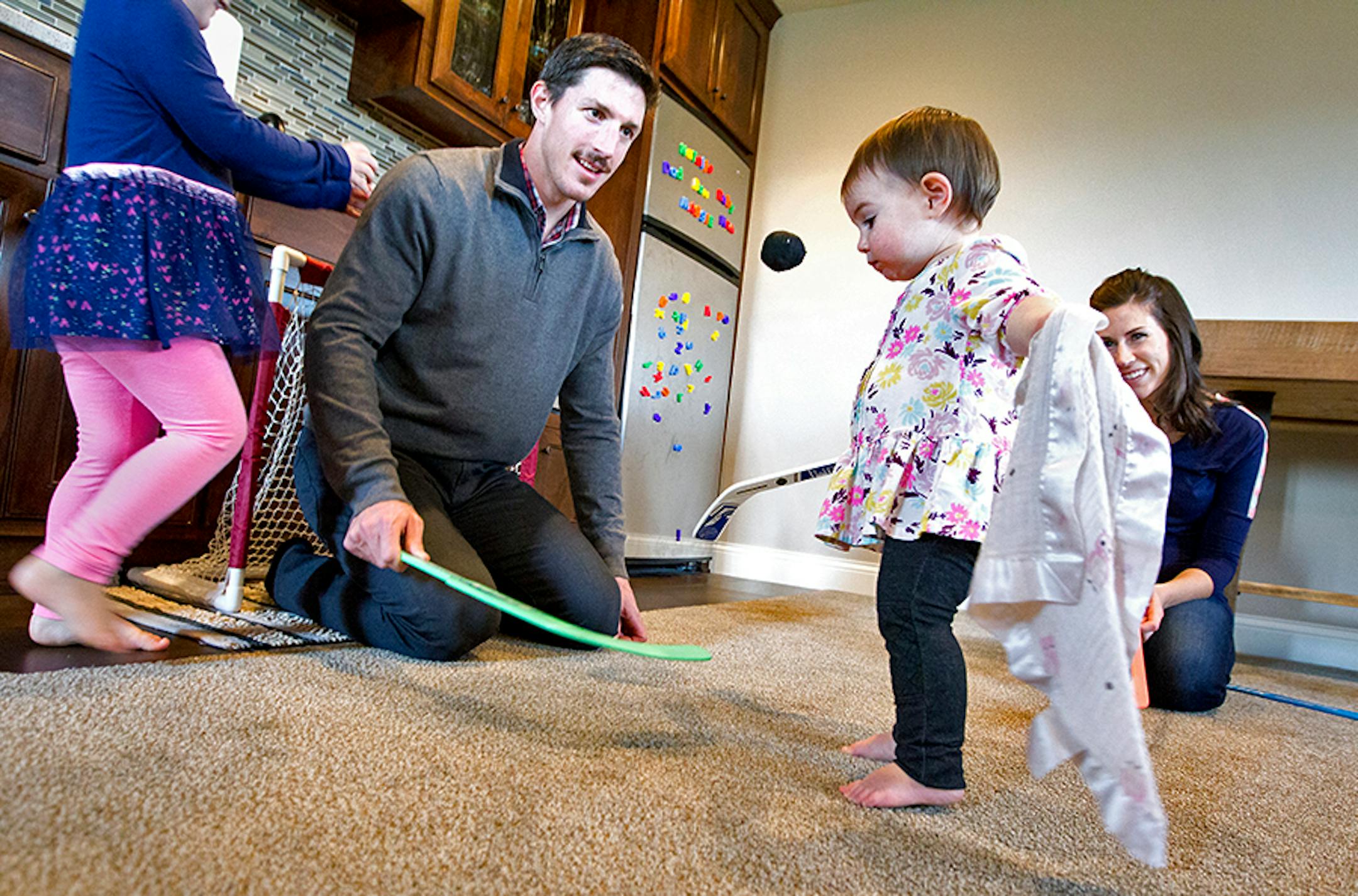 Minnesota Wild's Ryan Carter plays goalie during an impromptu hockey session at home with daughters Maggie, 3, left, and Natalie, 15 months, as his wife Erin looks on in Gem Lake November 22, 2015.