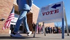 Voters walk past students to cast ballots in the presidential primary on March 5 at Highlands Elementary School in Edina.