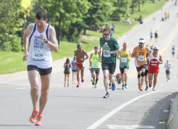 Matthew Perkett of Broomfield, Colorado, (right, in green) makes his way up Lemon Drop Hill during Grandma's Marathon on Saturday, June 17, 2017..