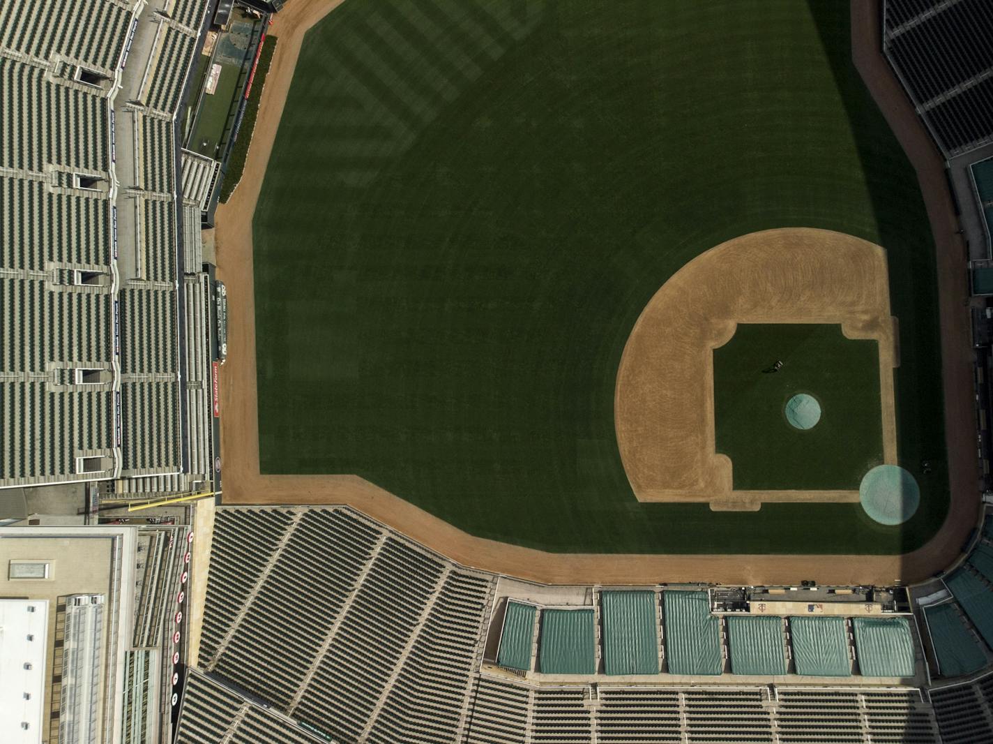 A skeleton crew of grounds keepers cut the grass at Target Field Friday afternoon.