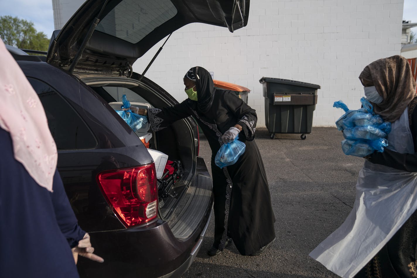 Aminata Keita loaded meals into the trunk of a car in Columbia Heights, Minn., on Thursday. She and other volunteers serve from 100 to 150 boxes each night for Muslims breaking their fasts at sundown, and who typically would be going to their mosque for a community meal.