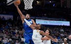 Timberwolves center Karl-Anthony Towns shoots next to Oklahoma City guard Shai Gilgeous-Alexander during the first half Friday night.