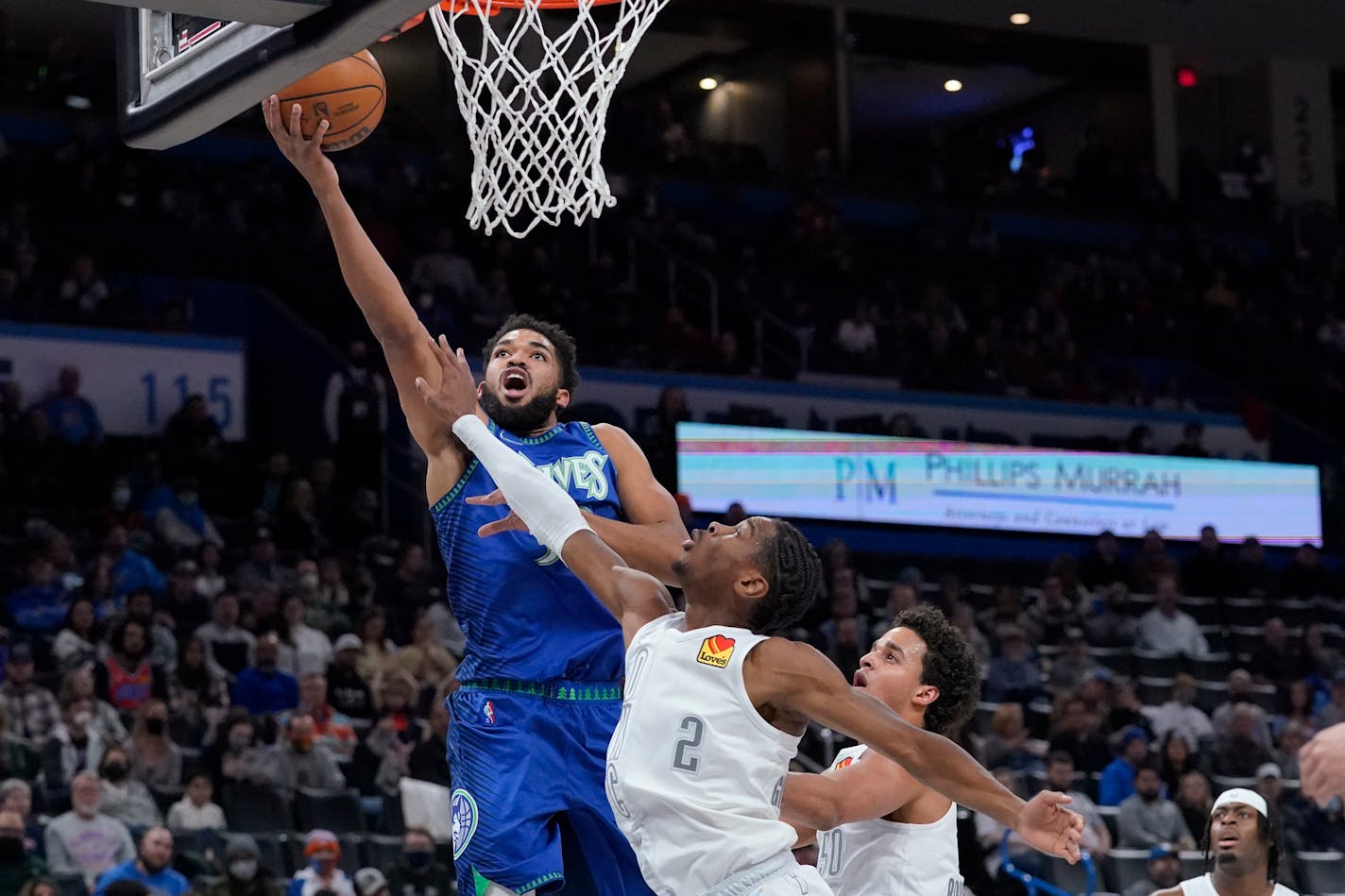 Timberwolves center Karl-Anthony Towns shoots next to Oklahoma City guard Shai Gilgeous-Alexander during the first half Friday night.