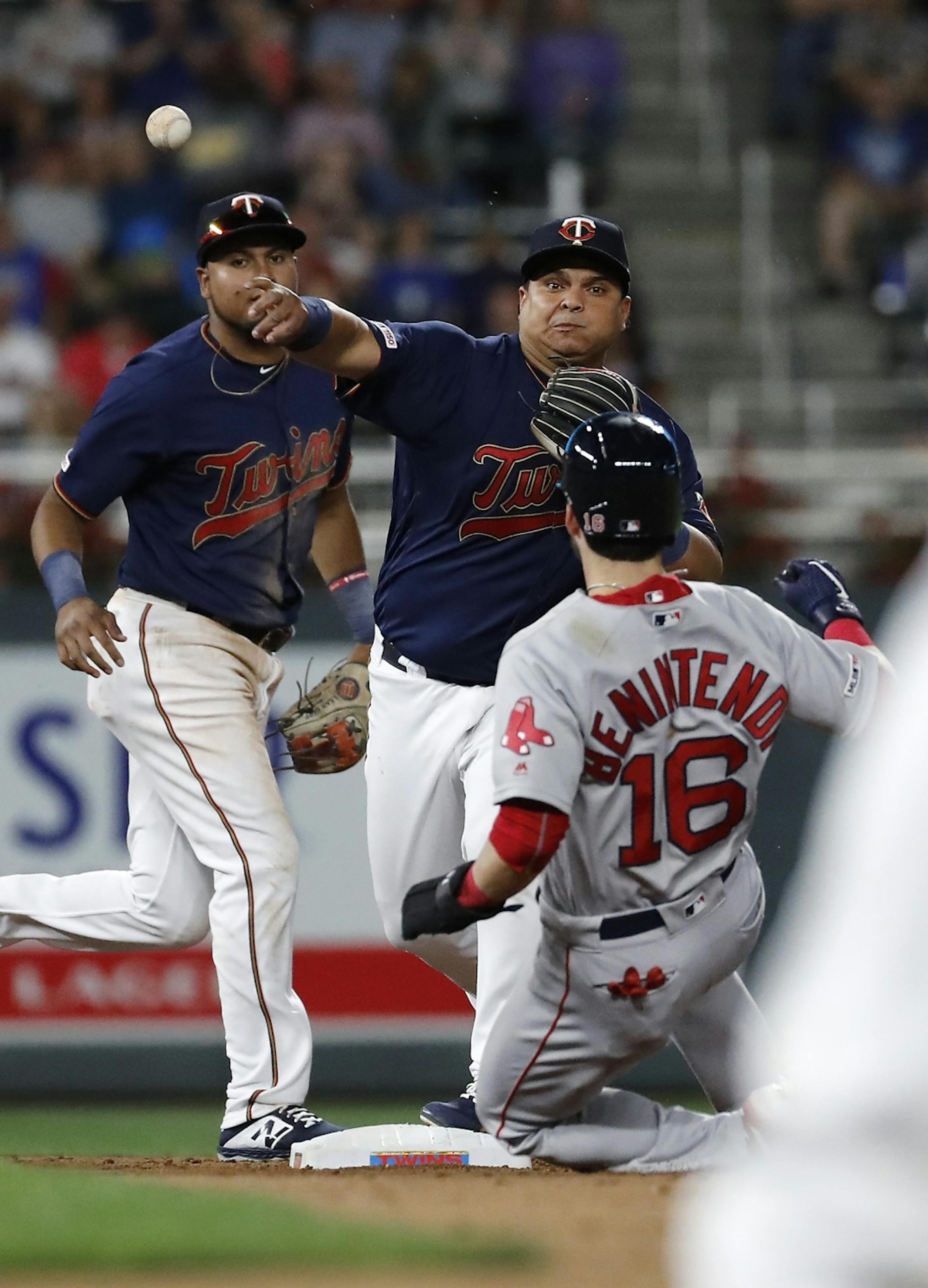 Minnesota Twins catcher Willians Astudillo (64) completes a double play in the sixth inning as Boston Red Sox left fielder Andrew Benintendi (16) slides into second base.