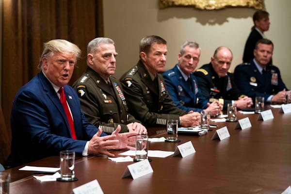 Then-President Donald Trump, seated next to Gen. Mark A. Milley, the chairman of the Joint Chiefs of Staff, makes remarks during a briefing with senio