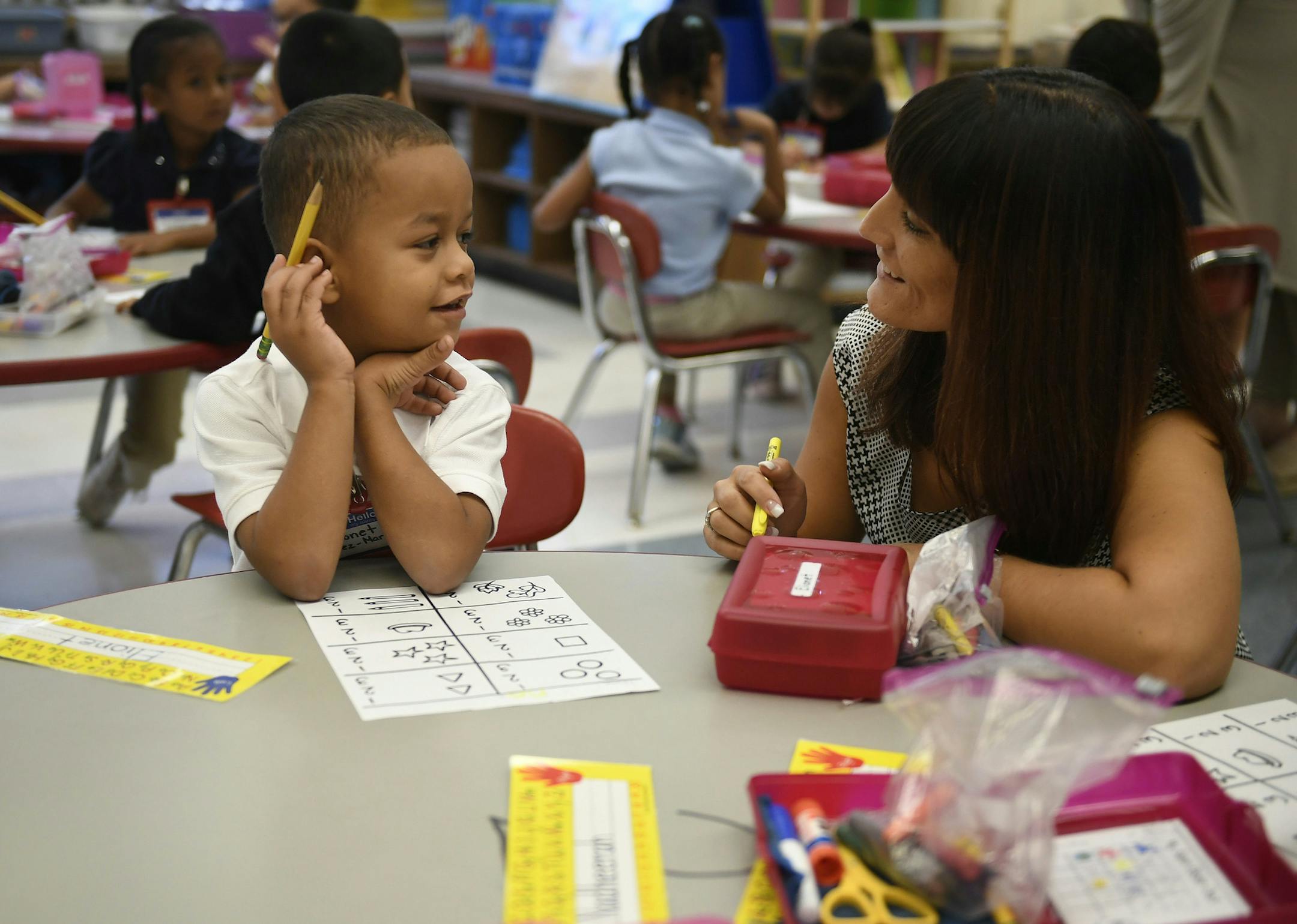 In this Friday, Sept. 29, 2017 photo, Elionet Saez Martin, of Puerto Rico, left, works with his kindergarten teacher Rachael Leupold, right, at Chamberlain Elementary School in New Britain, Conn. As Hurricane Maria churned toward Puerto Rico, Elionet's mother put him and his 9-year-old brother, Eliot, on a plane to be with their grandfather in Connecticut. The brothers are among the first of what is expected to be large numbers of Puerto Rican children enrolling in school districts on the U.S. m