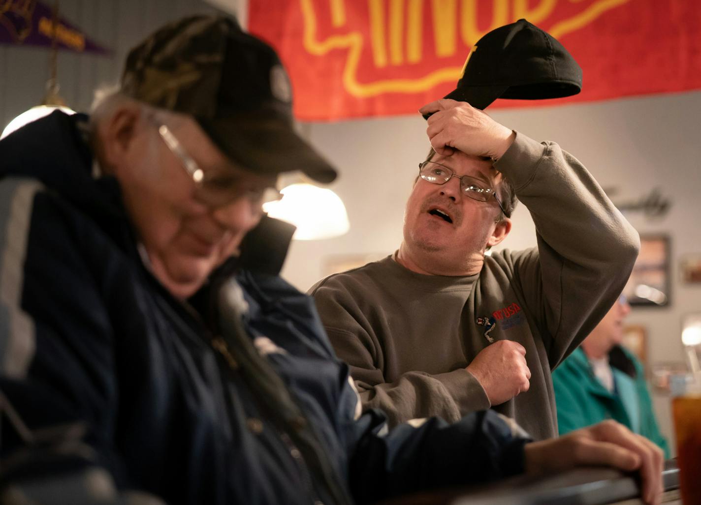 Friends Toby Crawford and Randy Stangl chatted at a bar in Charles City, Iowa, a thriving town with a large chicken processing plant.