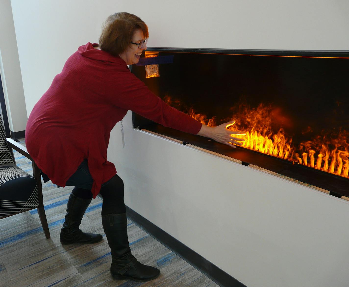 Carol Jackson, Shoreview library director, loves the wispy feel of the artificial fire: Soon it will be encased in glass.