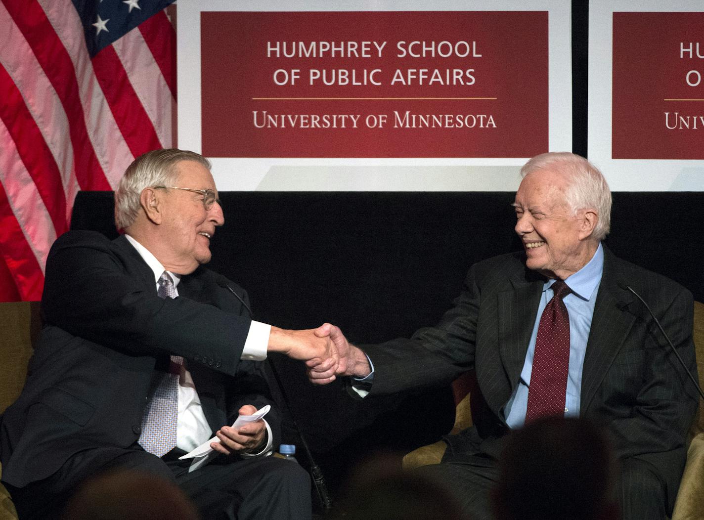 Former President Jimmy Carter shakes hands with former Vice President Walter Mondale, left, during a tribute for Mondale in Washington, Tuesday, Oct. 20, 2015. (AP Photo/Molly Riley)