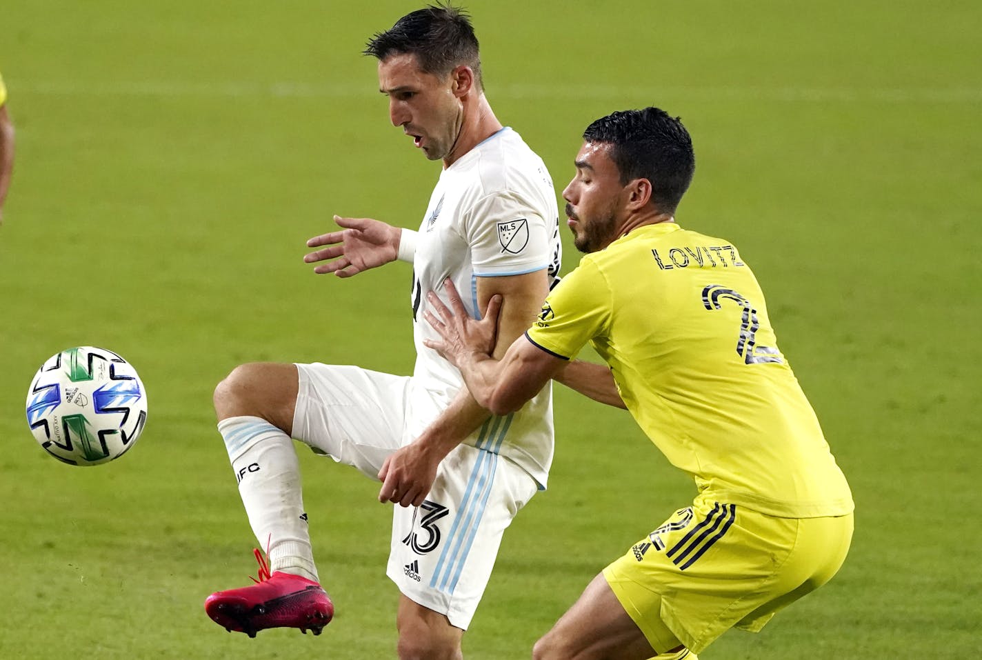 Minnesota United midfielder Ethan Finlay (13) passes the ball past Nashville defender Daniel Lovitz (2) during the second half of an MLS soccer match Tuesday, Oct. 6, 2020, in Nashville, Tenn. (AP Photo/Mark Humphrey)