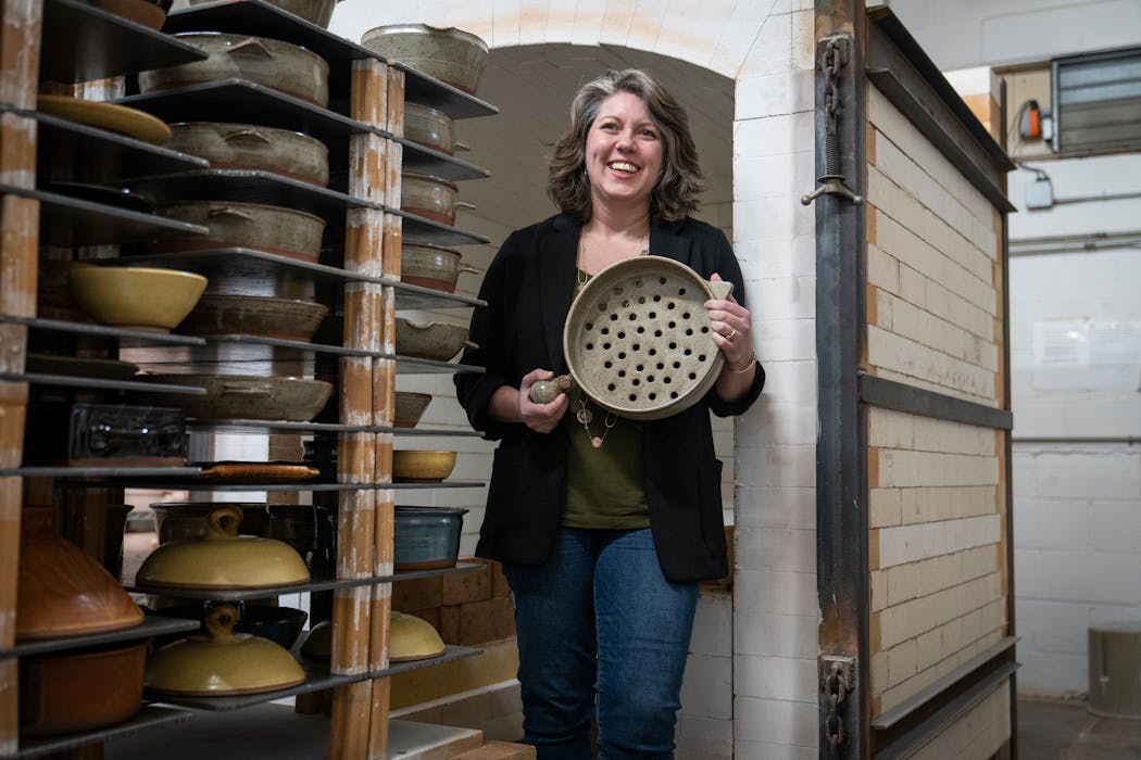 Morgan Baum, owner and CEO of Clay Coyote, in the kiln room of the Hutchinson studio with one of the flameware clay grill baskets.