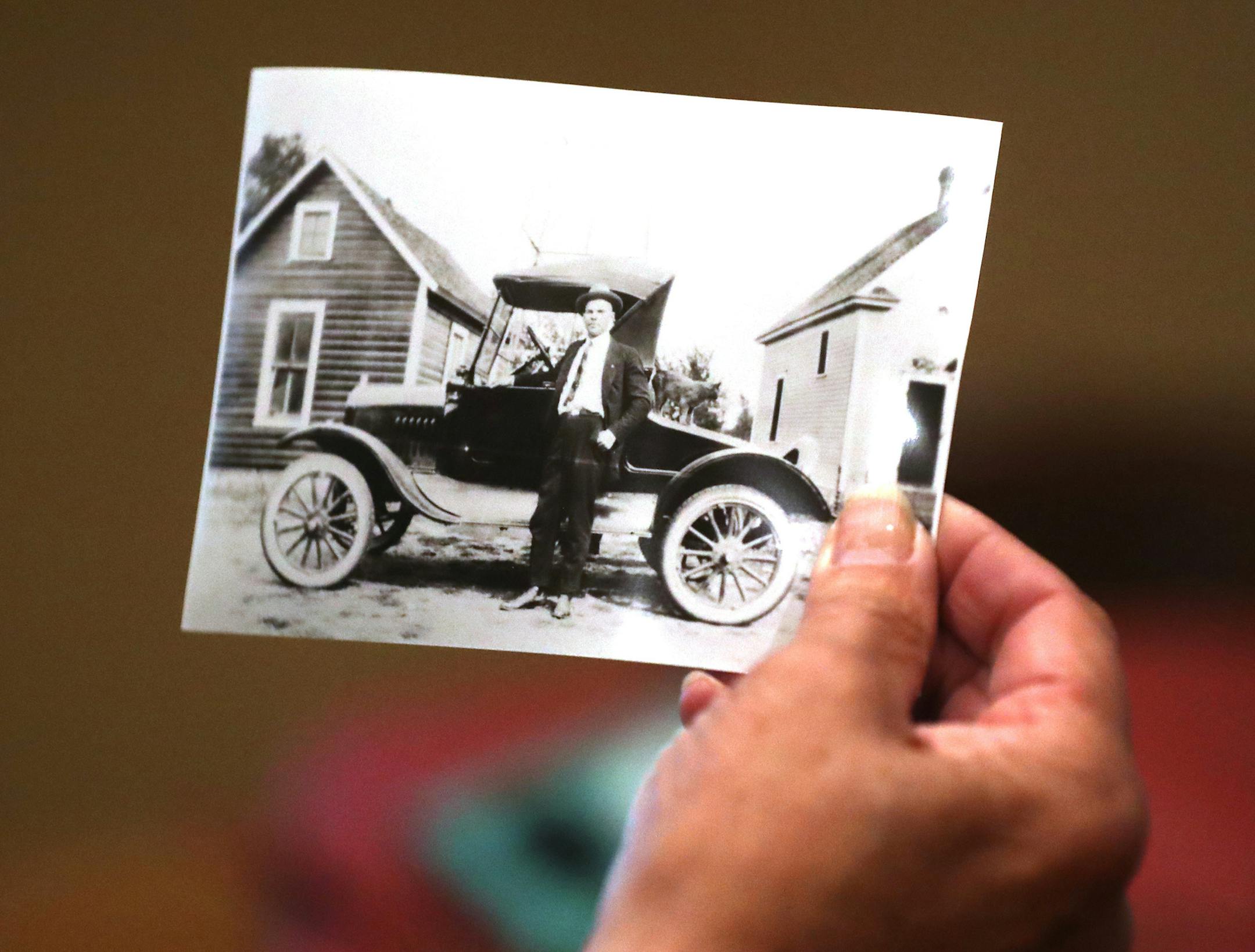 Jacci Krebsbach, president of the Shoreview Historical Society, holds a photo of former owner Art Larson with his car at the Lepak-Larson farmhouse.