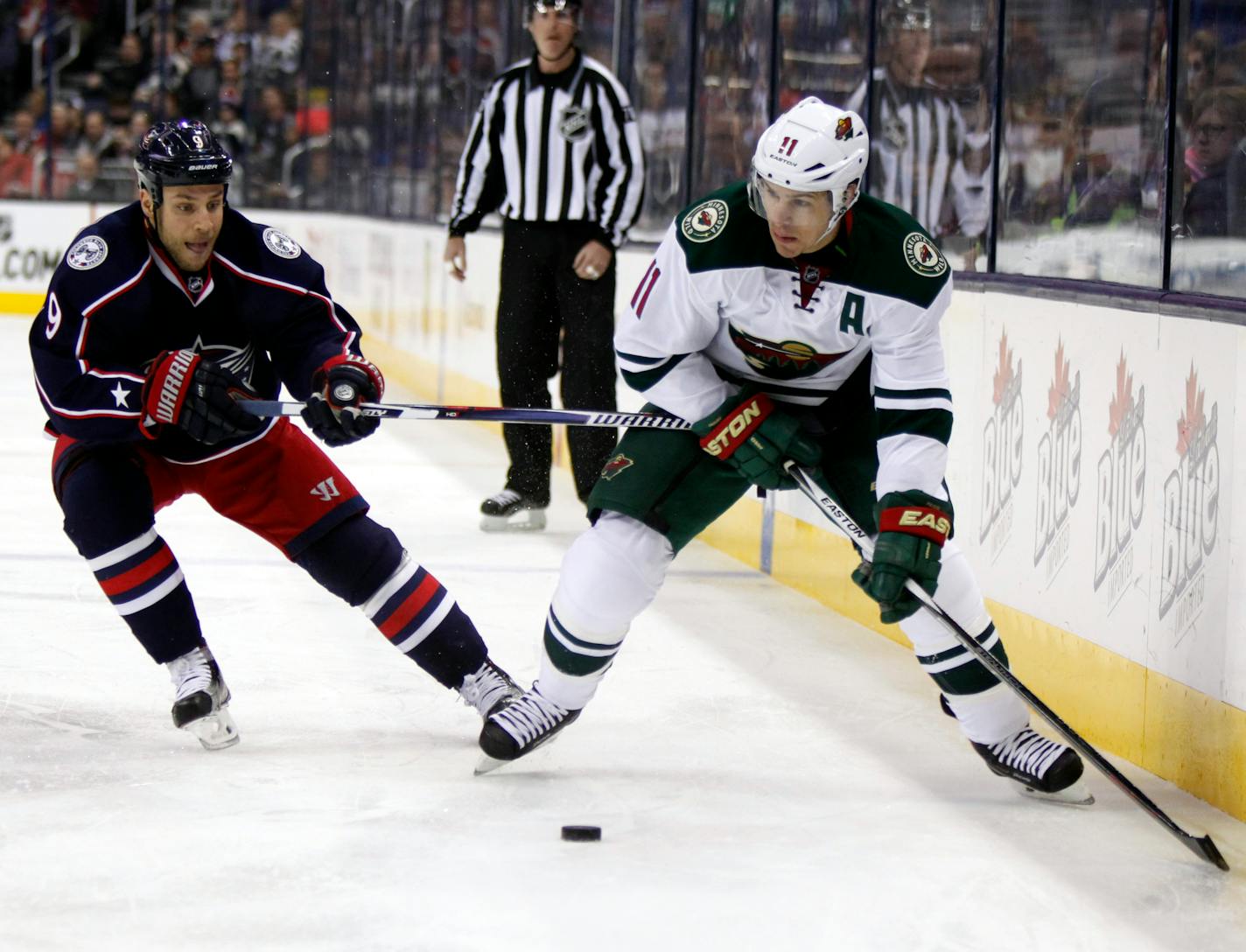 Minnesota Wild's Zach Parise, right, works for the puck against Columbus Blue Jackets' Gregory Campbell during the first period of an NHL hockey game in Columbus, Ohio, Tuesday, Jan.5, 2016. (AP Photo/Paul Vernon)