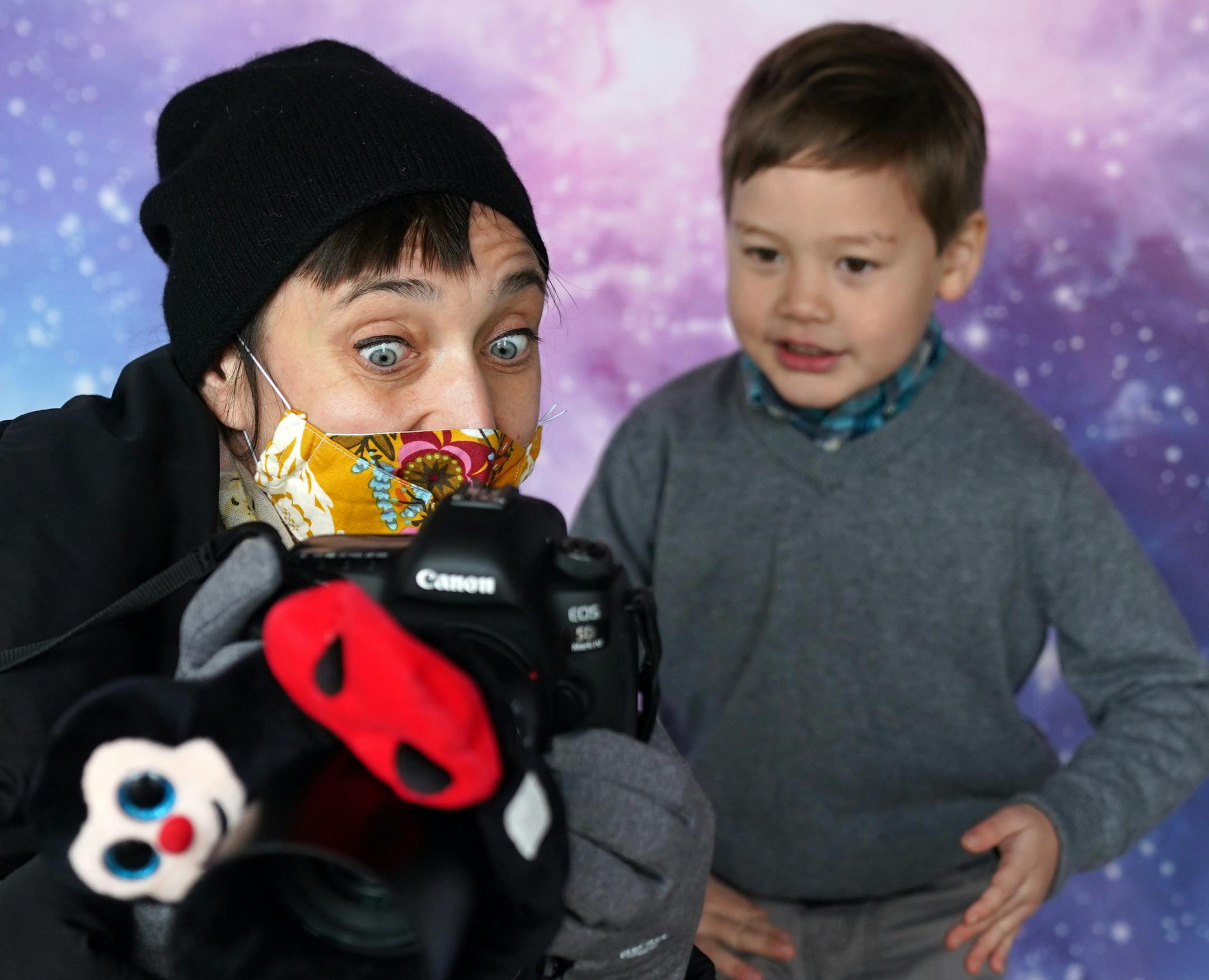 Minneapolis photographer Alison Malone showed photos to Charlie Kazama, 5, as she photographed him against an outer space background. ] ANTHONY SOUFFLE • anthony.souffle@startribune.com Minneapolis photographer Alison Malone took "school picture" style portraits outside her studio for kids whose schools are in distance learning but whose parents still want school pictures Saturday, Oct. 24, 2020 in northeast Minneapolis.