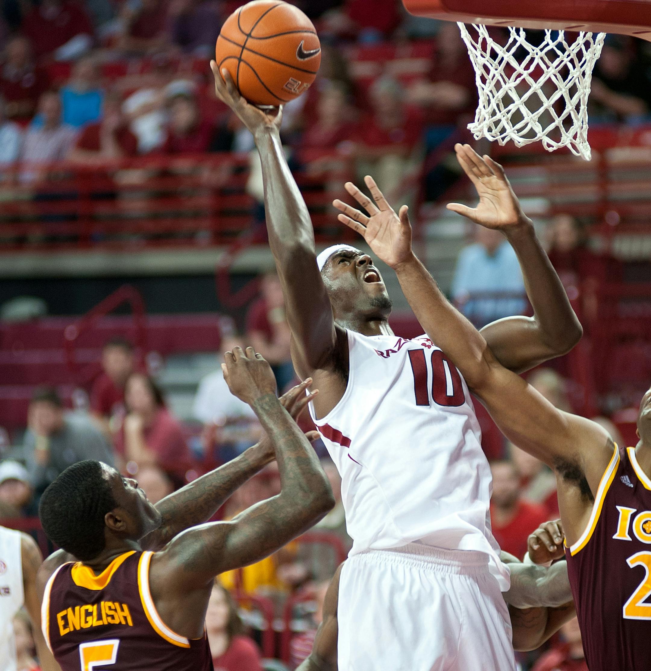 Arkansas' Bobby Portis (10) reaches up for the basket as Iona's A.J. English (5) and Jeylani Dublin (21) defend in the first half of an NCAA college basketball game in Fayetteville, Ark., Sunday, Nov. 30, 2014. (AP Photo/Sarah Bentham)