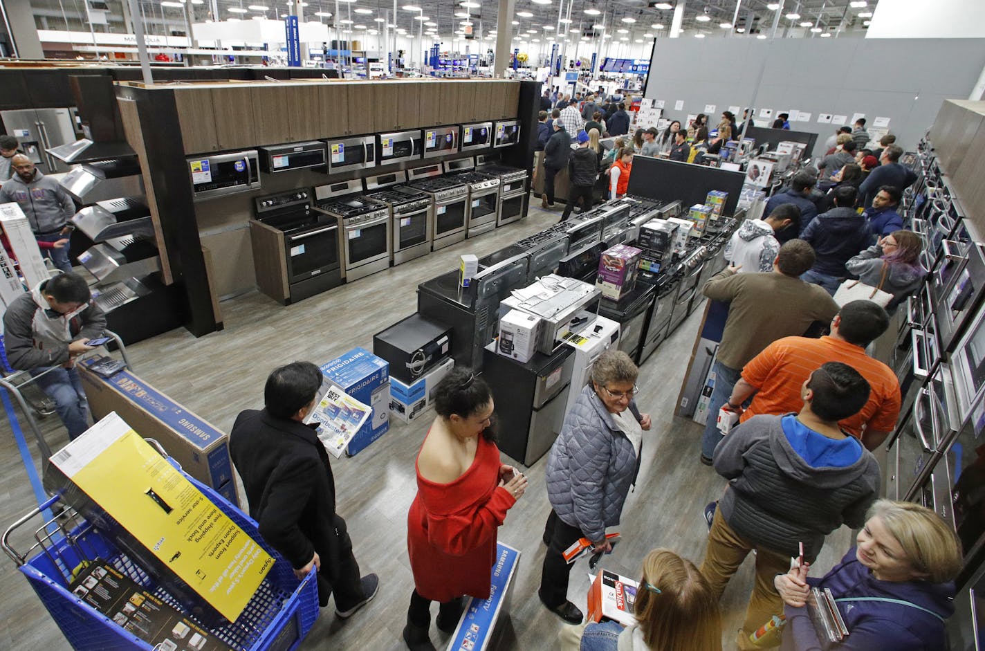 FILE- In this Nov. 22, 2018, file photo people line up to pay for their purchases as they shop during an early Black Friday sale at a Best Buy store on Thanksgiving Day in Overland Park, Kan. Consumer spending rose a sharp 0.6 percent last month, the Commerce Department reported Thursday, Nov. 29. (AP Photo/Charlie Riedel, File) ORG XMIT: NYBZ416