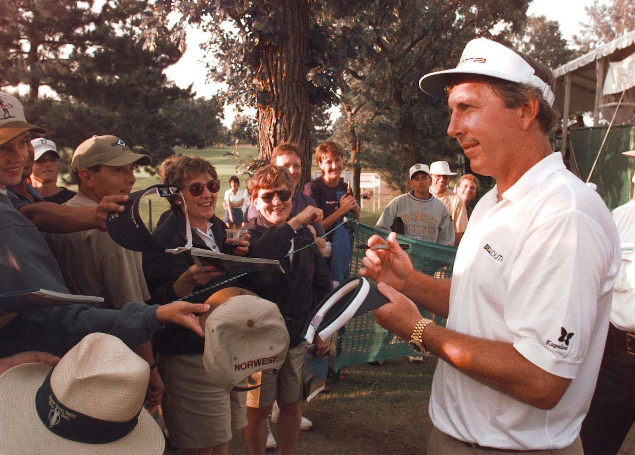 Leader after two rounds, Hale Irwin signs autographs for fans near the 18th green. Irwin hit a 68 and now stands 11 under par for two rounds.