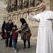 Visitors pose next to the life-size wax model of Pope Francis as it is presented by the Grevin Museum in front of Notre Dame cathedral, Paris, as part