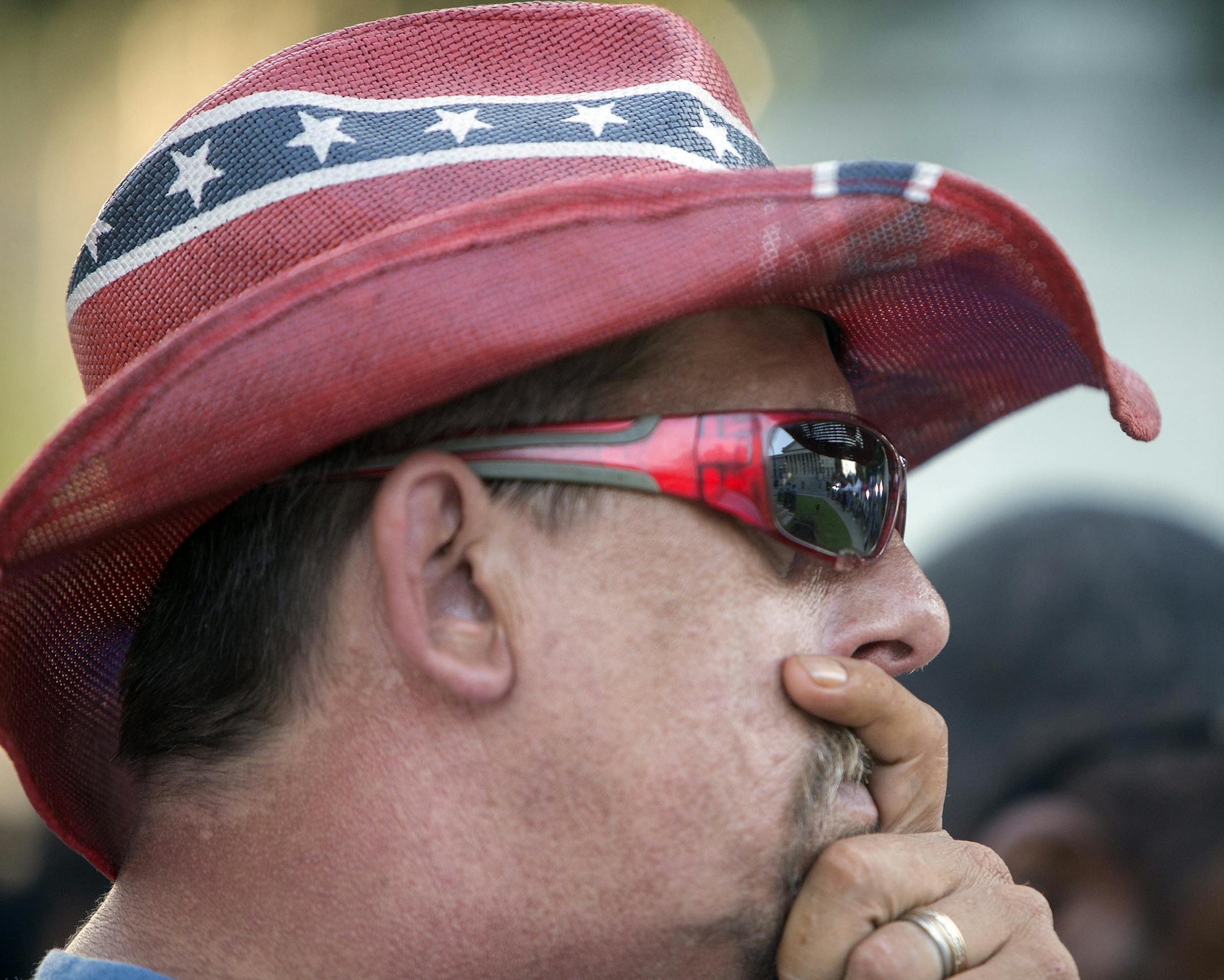 John Blankenship, of Granite Falls, N.C., wears a rebel flag themed hat as he waits for the Confederate battle flag to be removed from the grounds of the State House in Columbia, S.C., the morning of July 10, 2015. In a historic moment for South Carolina, the flag is set to be removed from its 30-foot pole on Friday morning.